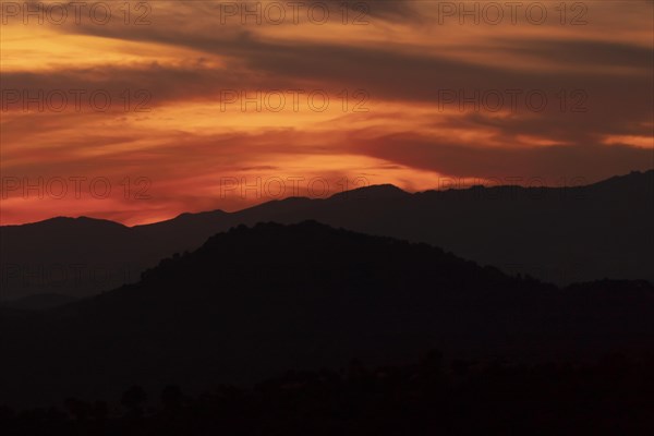 Dark yellow clouded sky with black mountains