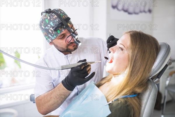 Dentist doing dental treatment female patient