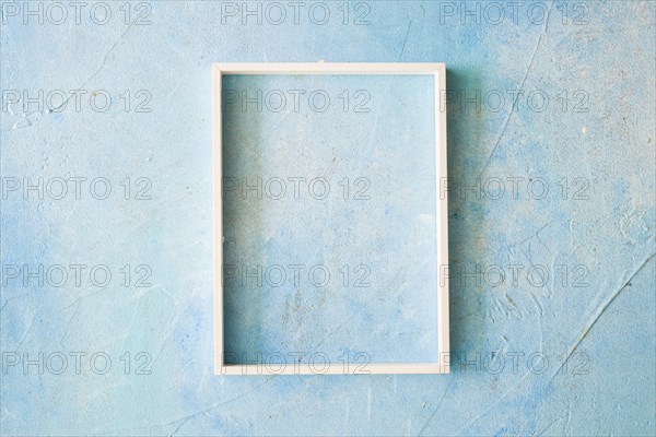 Empty frame with white border blue painted wall