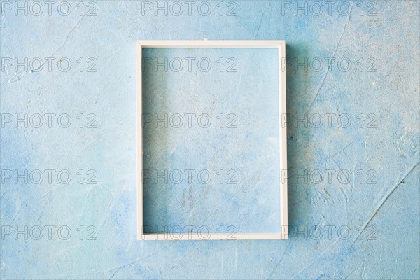 Empty frame with white border blue painted wall