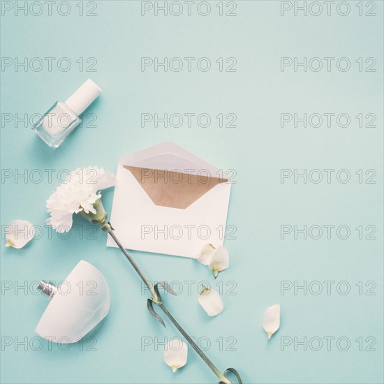 Envelope with white flower perfume blue table