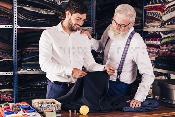 Fashion designer customer looking fabric his shop