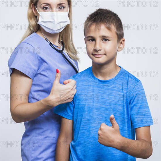 Female dentist boy gesturing thumbs up