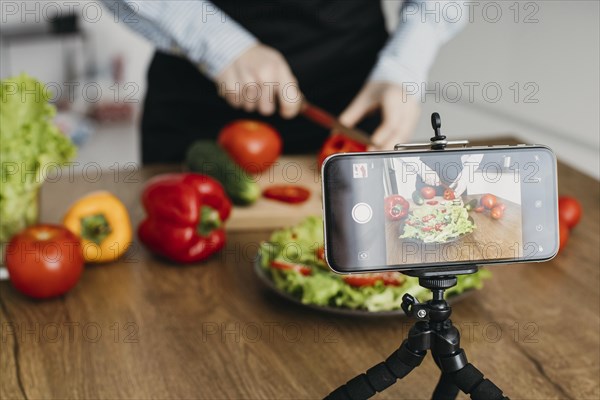 Female food blogger streaming home while cooking