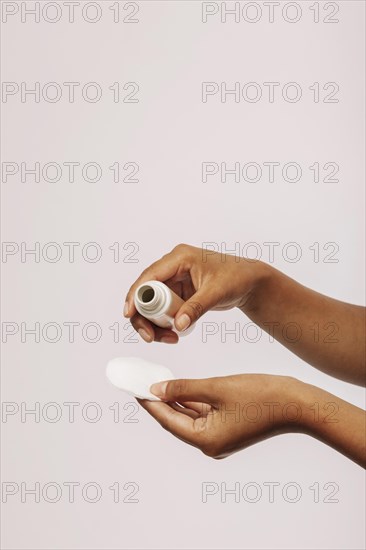 Female hands with cosmetic product cotton pad