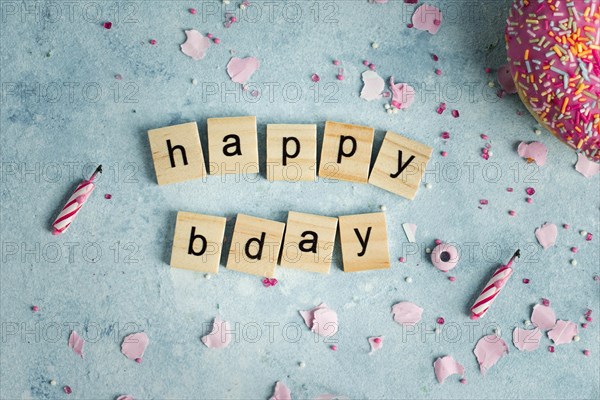 Flat lay happy birthday wish wooden letters with doughnut