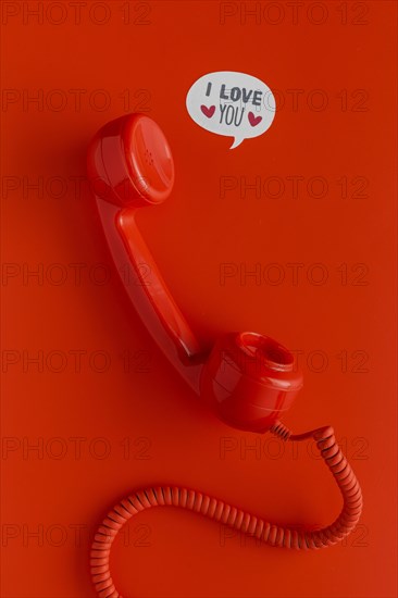 Flat lay telephone receiver with cord chat bubbles