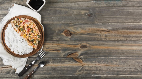 Fried steamed rice wooden plate with fork spoon table