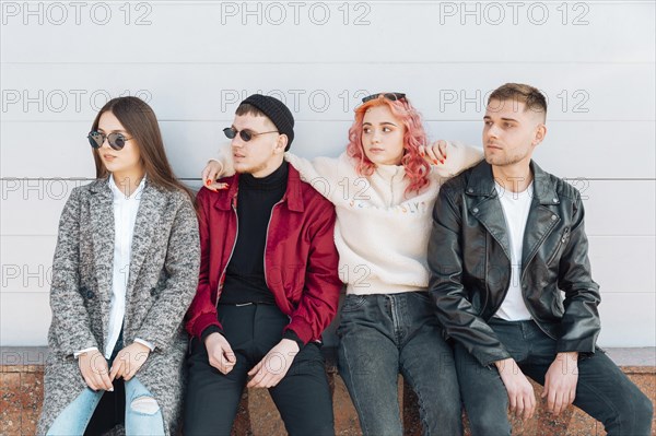 Friends sitting bench looking same direction