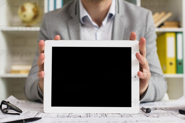 Front view businessman holding tablet mock up