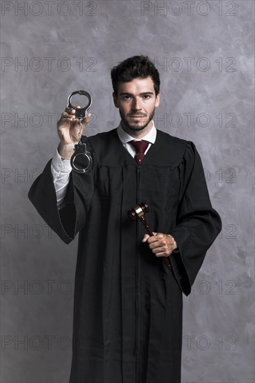 Front view judge robe with handcuffs gavel