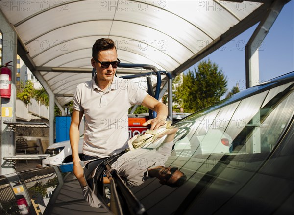 Front view man cleaning windscreen