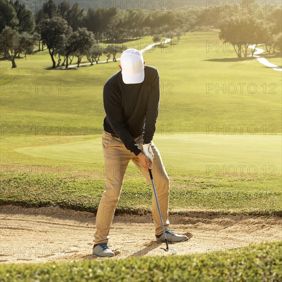 Front view man playing golf with club