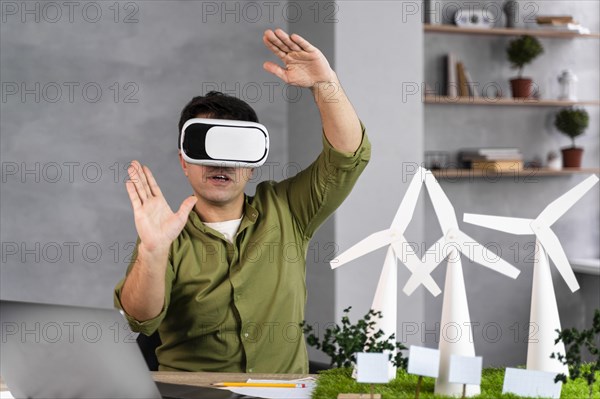 Front view man working eco friendly wind power project using virtual reality headset