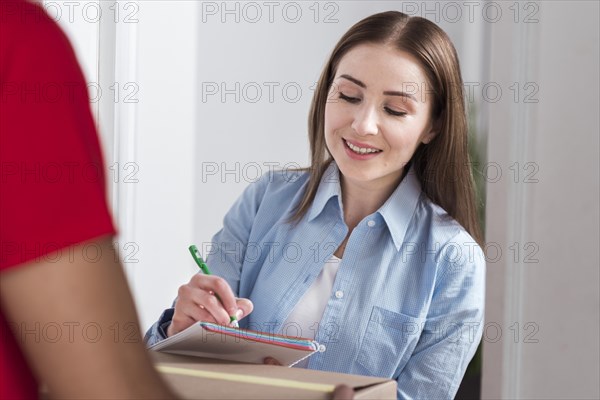 Front view woman signing forms delivery