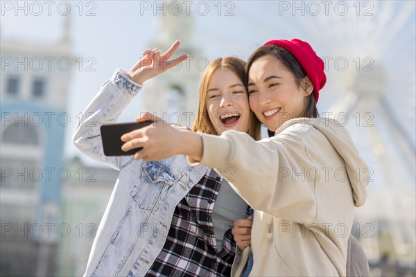Girlfriends taking selfie with london eye