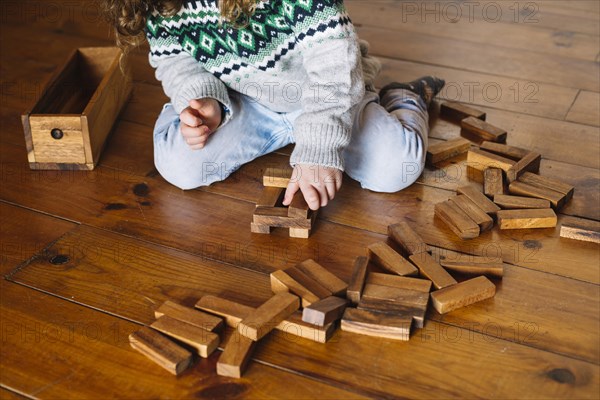 Girl s hand playing wooden block game home