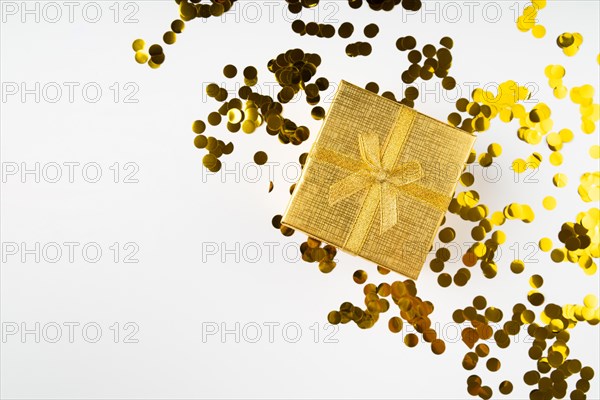 Golden wrapped gift surrounded by confetti