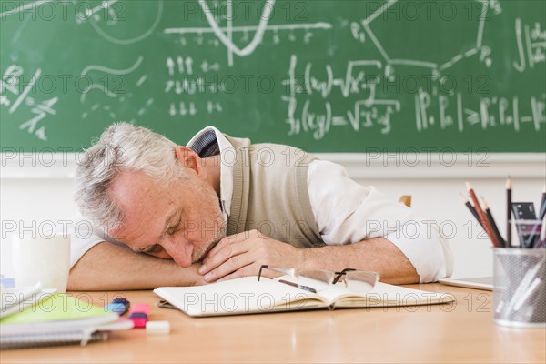 Grey haired teacher sleeping table