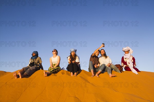 Group people sitting top dune
