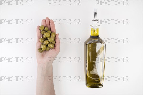 Hand holding olives bottle oil