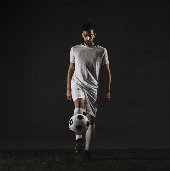 Handsome sportsman juggling ball