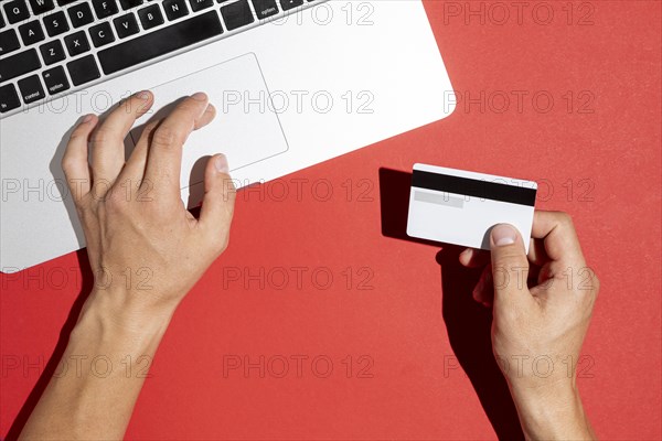 Hands using computer holding credit card