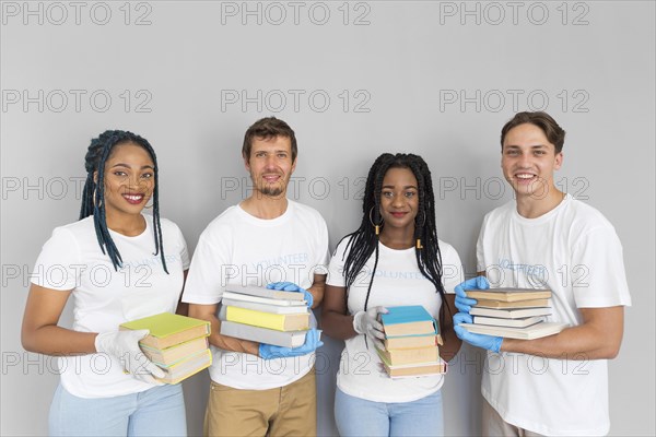 Happy people holding bunch books donate them