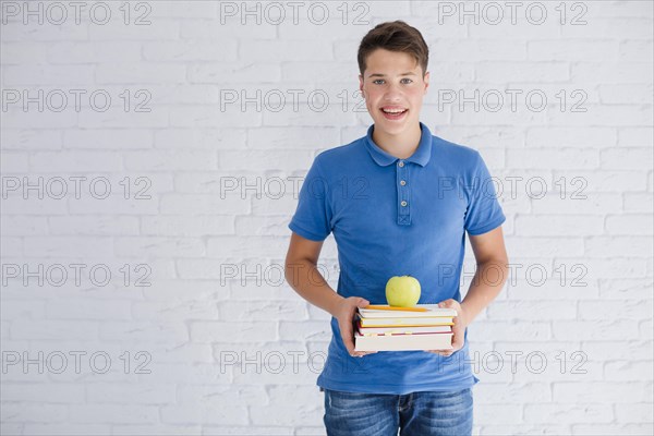 Happy teen boy with books