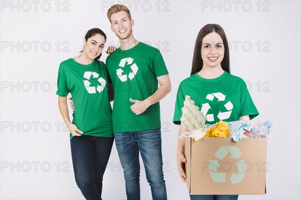 Happy woman holding cardboard box full recycle items