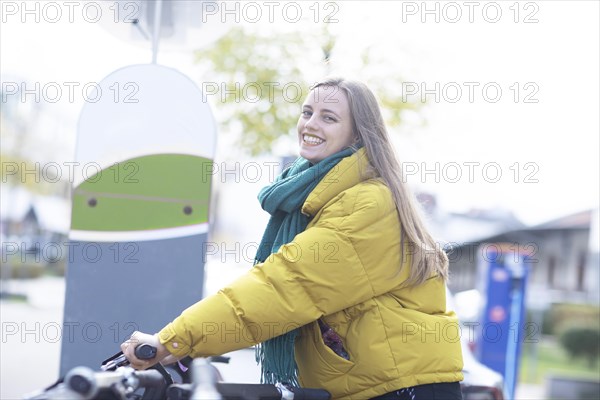 Young woman with bike station Rent a bike in the city