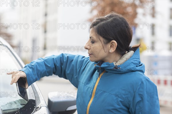 Woman uses car sharing car in a city street