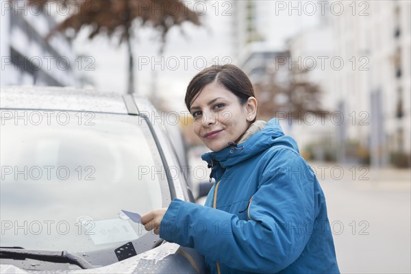 Woman uses car sharing car in a city street