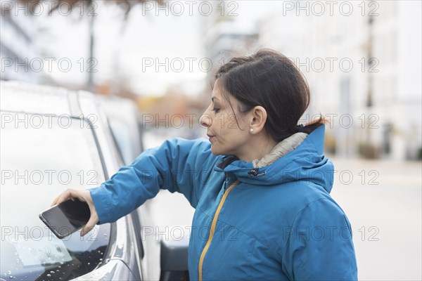 Woman uses car sharing car in a city street