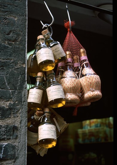 Bottles of olive oil and red wine in a demijohn as decoration at a shop in Tuscany