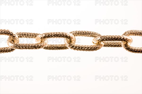 Gold color metal chain on white background