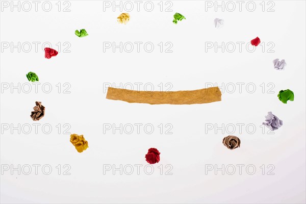 Colorful crumpled papers form a round shape on white background