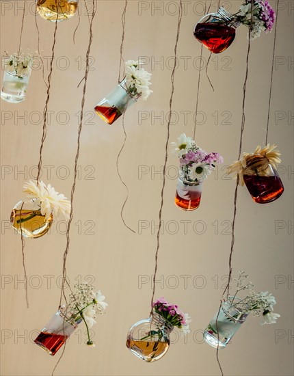 Herbal tea bottles with flowers hanging on strings