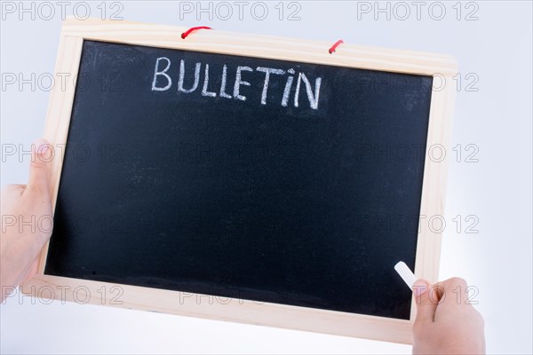 Hand holding the board with the title of bulletin