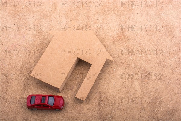 Paper house and a model car on a canvas background