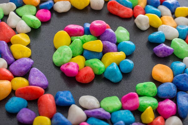 Pile of little colorful pebbles on black background