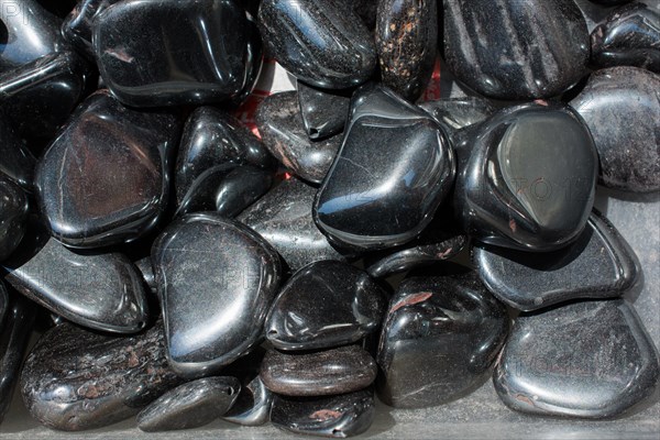 Shiny metallic gray tumbled hematite gemstone as mineral rock