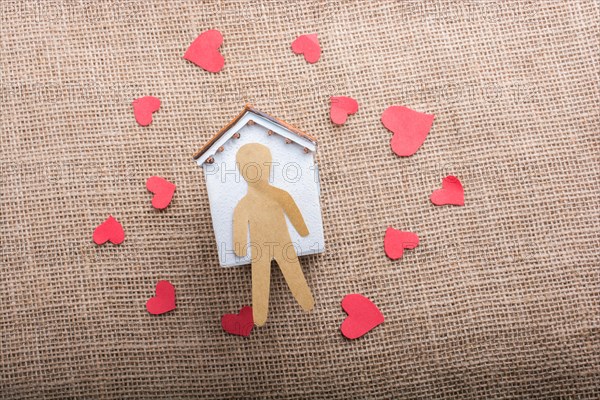 Heart shaped icons and paper house on canvas