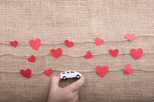 Love concept with car and paper heart on linen threads