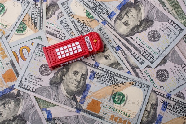 Model telephone booth is placed on spread US dollar Banknotes