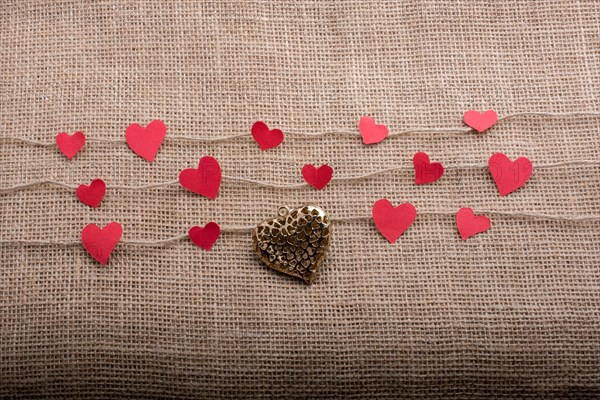 Love concept with heart shaped papers on linen threads