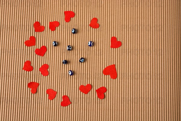 Love concept with red paper hearts and evil eye beads beads