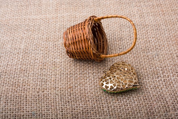 Heart shaped object beside a basket on canvas