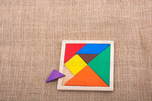 Colorful pieces of a square tangram puzzle