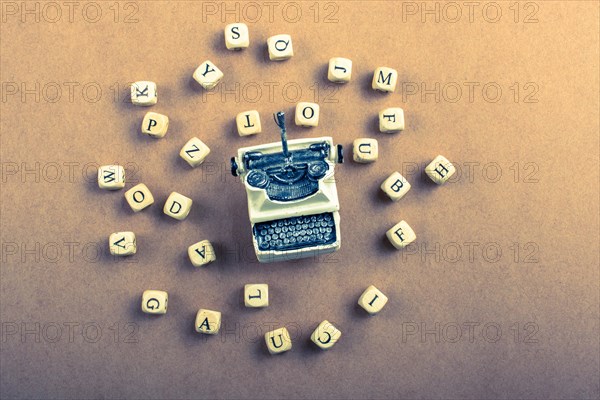 Letter cubes of made of wood around model typewritter